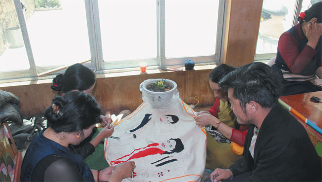 ལི་ཐང་གི་བོད་རིགས་བུད་མེད་ཀྱིས་རང་ཉིད་ཀྱི་ལག་གཉིས་ལ་བརྟེན་ནས་དབུལ་སྒྲོལ་ལམ་བུ་བཏོད་པ།